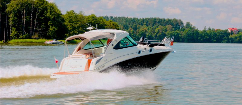 Boat glides across a like on a sunny day